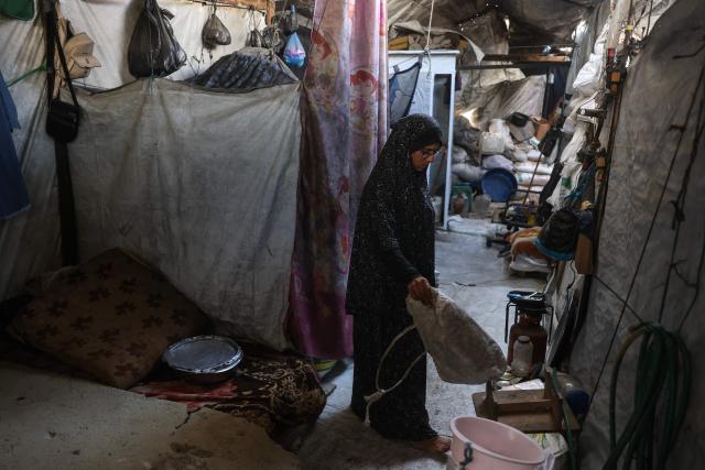 This photo taken on October 6, 2026 shows Nihaya Al-Masri, a 35-year-old displaced Palestinian woman from Beit Hanoun, standing at the makeshift shelter where she lives with her husband and their six children in Khan Yunis, in the southern Gaza Strip. Every day, Gazan mother Niyaha al-Masri spends six exhausting hours or more queueing at a community kitchen in the hope of getting some food for her family. It has been a year since a ceasefire between Hamas and Israel was supposed to allow food to flood into the ruined territory, yet the hunger crisis there persists. (Photo by Bashar Taleb / AFP) / To go with 'ISRAEL-PALESTINIANS-CONFLICT-GAZA-HUNGER, FOCUS" by AFP team in Gaza, with Anouk RIONDET in Jerusalem