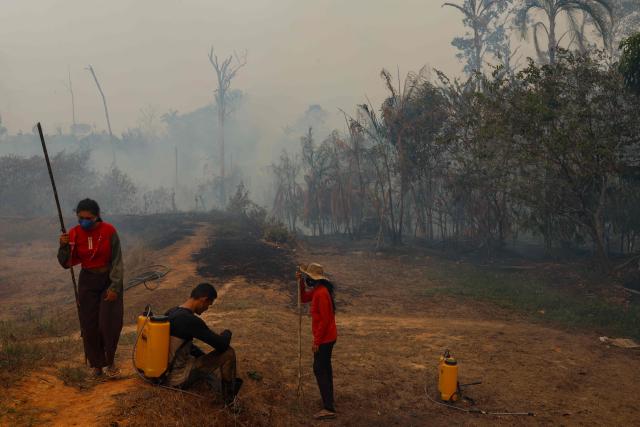 Residents gather to try to contain a forest fire that is approaching homes in the rural area of Autazes, in the state of Amazonas, northern Brazil, on October 9, 2026. (Photo by MICHAEL DANTAS / AFP)