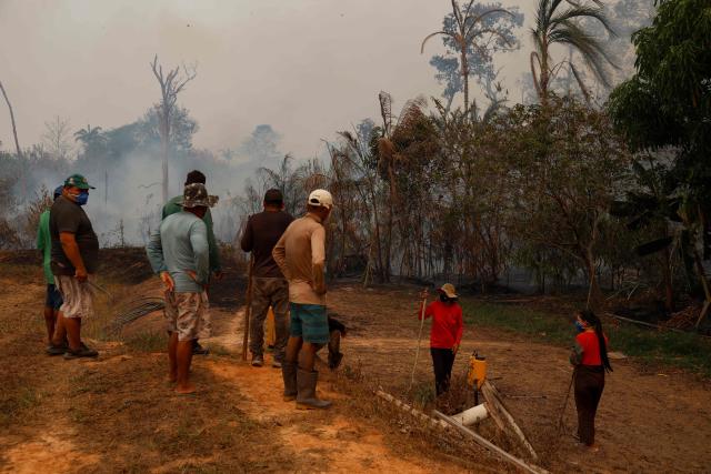 Residents gather to try to contain a forest fire that is approaching homes in the rural area of Autazes, in the state of Amazonas, northern Brazil, on October 9, 2026. (Photo by MICHAEL DANTAS / AFP)