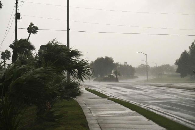 A road is seen empty as the strong winds of Hurricane Isaias hit Pensacola, Florida, on October 9, 2026. Hurricane Isaias' outer bands were lashing the US Gulf Coast with heavy rain and strong winds Friday, with the category 3 storm triggering mandatory evacuations and poised to bring life-threatening storm surge when it makes landfall. (Photo by RONALDO SCHEMIDT / AFP)