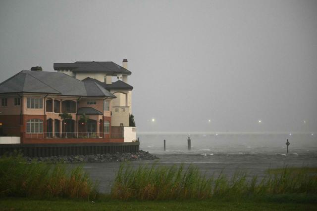 A house is battered by the strong winds and storm surge of Hurricane Isaias in Pensacola, Florida, on October 9, 2026. Hurricane Isaias' outer bands were lashing the US Gulf Coast with heavy rain and strong winds Friday, with the category 3 storm triggering mandatory evacuations and poised to bring life-threatening storm surge when it makes landfall. (Photo by RONALDO SCHEMIDT / AFP)