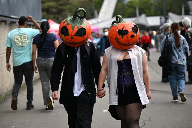 A couple wearing pumpkin heads takes part in the SOFA Leisure and Fantasy Fair in Bogotá, Colombia, on October 9, 2026. (Photo by Raul ARBOLEDA / AFP)