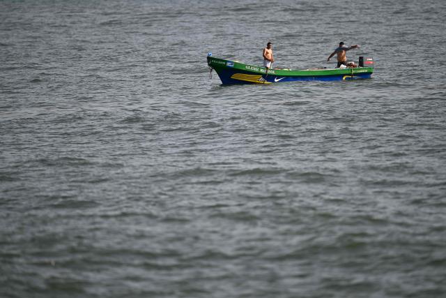 Fishermen change clothes aboard their boat after finishing their fishing trip, before returning to the port of La Libertad, El Salvador, to sell their catch, on October 9, 2026. (Photo by Marvin RECINOS / AFP)