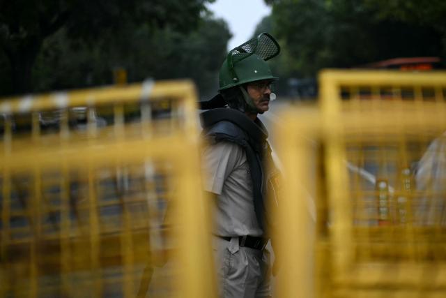 A Delhi Police personnel stands guard ahead of a protest by the youth-led Cockroach Janata Party (CJP) demanding the resignation of India’s Chief Election Commissioner over alleged "special intensive revision” (SIR) voter-roll irregularities, in New Delhi on October 10, 2026. India deployed thousands of police in its capital and restricted transportation in and around Delhi ahead of mass demonstrations on October 10 demanding the resignation of the country's election chief over alleged voter-roll irregularities. (Photo by Manan VATSYAYANA / AFP)
