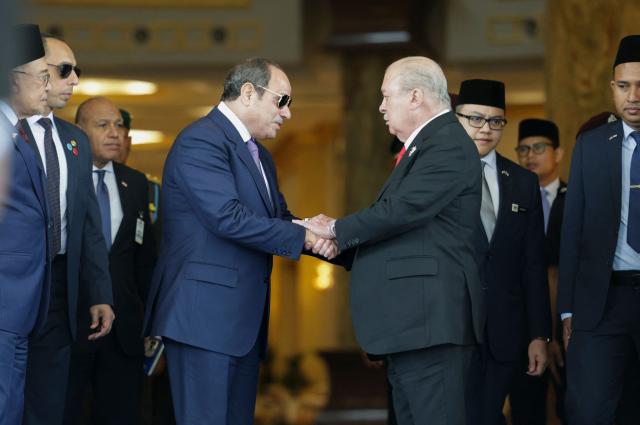 Egypt's President Abdel Fattah al-Sisi (centre L) and Malaysia's King Sultan Ibrahim Sultan Iskandar shake hands after attending a state banquet during al-Sisi's state visit at the National Palace in Kuala Lumpur on October 10, 2026. (Photo by Hasnoor Hussain / POOL / AFP)