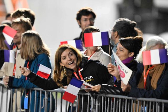 Friends and family of European Space Agency (ESA) French astronaut Sophie Adenot wait for her arrival at the Military Airport in Cologne, in the early hours of the morning on October 10, 2026, the day after she and three colleagues splashed down in the Pacific Ocean returning from their mission at the International Space Station (ISS). Sophie Adenot became the first French female astronaut to venture outside the International Space Station (ISS) for a spacewalk in late August 2026. (Photo by INA FASSBENDER / AFP)