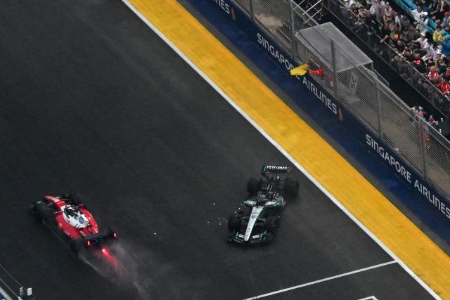 Ferrari's Monegasque driver Charles Leclerc (L) drives past Mercedes' British driver George Russell after the latter suffered a crash during the sprint race ahead of the Formula One Singapore Grand Prix at the Marina Bay Street Circuit in Singapore on October 10, 2026. (Photo by ROSLAN RAHMAN / AFP)