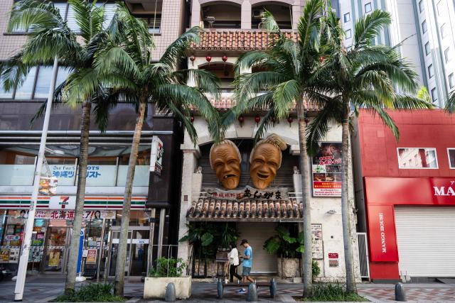 Tourists pass shops in downtown Naha, Okinawa prefecture on October 10, 2026. (Photo by ANDREW CABALLERO-REYNOLDS / AFP)