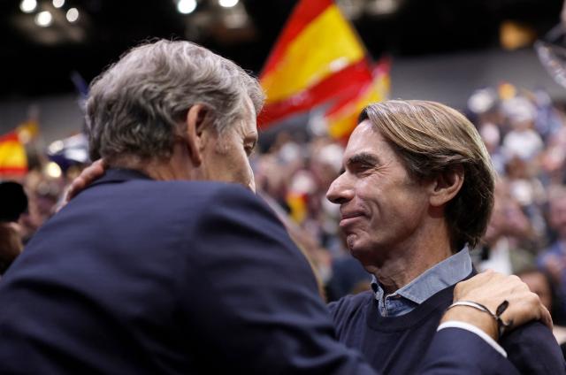 Spain's opposition Partido Popular (PP) party's leader Alberto Nunez Feijoo (R) greets Spain's former Prime Minister Jose Maria Aznar as he arrives to a campaign rally in Madrid on October 10, 2026. Spain's Prime Minister called a snap election for November 29, after parliament rejected housing relief measures proposed by his minority government amid nationwide protests. The defeat was just the latest political setback for one of the few left-leaning government leaders still in power in Europe. (Photo by Oscar DEL POZO / AFP)