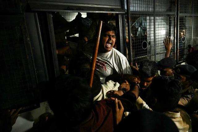 TOPSHOT - Police personnel detain supporters of the Cockroach Janata Party (CJP) during a protest demanding the resignation of India’s Chief Election Commissioner Gyanesh Kumar over alleged voter roll irregularities linked to the "special intensive revision" (SIR), in Ahmedabad on October 10, 2026. (Photo by Shammi MEHRA / AFP) / ALTERNATIVE CROP
