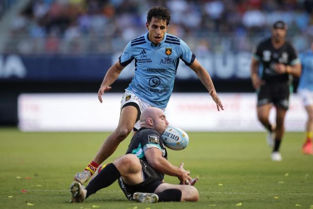 Vannes' Scottish hooker Dave Cherry (bottom) gets hit in the head by the ball next to Perpignan's French wing Théo Forner during the French Top14 rugby union match between USA Perpignan and RC Vannes at the Aime-Giral stadium in Perpignan, south-western France on October 10, 2026. (Photo by Valentine CHAPUIS / AFP)