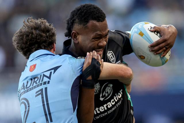 Vannes' Fijian center Inia Tabuavou (R) is tackled by Perpignan's South African full-back Tristan Tedder (L) during the French Top14 rugby union match between USA Perpignan and RC Vannes at the Aime-Giral stadium in Perpignan, south-western France, on October 10, 2026. (Photo by Valentine CHAPUIS / AFP)