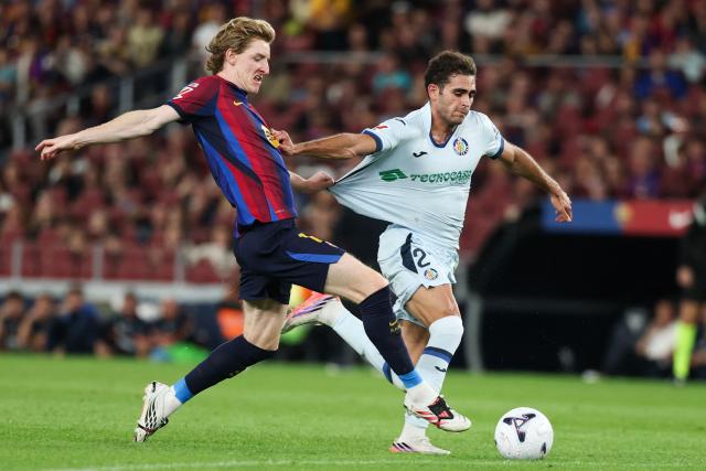 Barcelona's English forward #17 Anthony Gordon (L) vies with Getafe's Spanish defender #21 Andres Garcia Robledo during the Spanish league football match between FC Barcelona and Getafe CF at Camp Nou Stadium in Barcelona on October 10, 2026. (Photo by Lluis GENE / AFP)