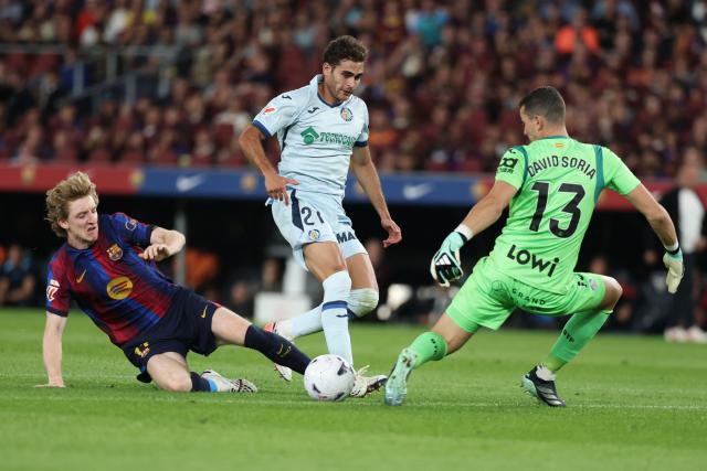 Barcelona's English forward #17 Anthony Gordon (L) tries to score past Getafe's Spanish goalkeeper #13 David Soria (R) and Getafe's Spanish defender #21 Andres Garcia Robledo during the Spanish league football match between FC Barcelona and Getafe CF at Camp Nou Stadium in Barcelona on October 10, 2026. (Photo by Lluis GENE / AFP)