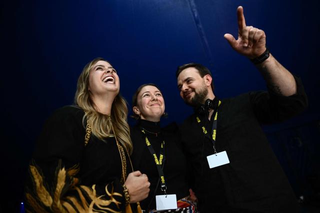 Siobhan o'Grady (C), Serhii Korolchuk (R) and Anastacia Galouchka (L) react as they receive the printed press prize of the international jury, Prix du Departement du Calvados for the report "A soldier trapped in a kill zone for 177 days. His wife's voice was his lifeline" for the Washington Post during the award ceremony of the 2026 edition of the "Prix Bayeux Calvados-Normandie of the war correspondants", in Bayeux, northwestern France, on October 10, 2026. (Photo by Guillaume Saligot / AFP)