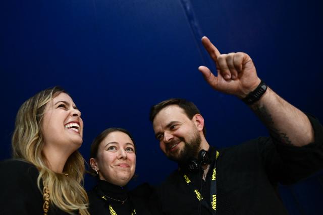 Siobhan o'Grady (C), Serhii Korolchuk (R) and Anastacia Galouchka (L) react as they receive the printed press prize of the international jury, Prix du Departement du Calvados for the report "A soldier trapped in a kill zone for 177 days. His wife's voice was his lifeline" for the Washington Post during the award ceremony of the 2026 edition of the "Prix Bayeux Calvados-Normandie of the war correspondants", in Bayeux, northwestern France, on October 10, 2026. (Photo by Guillaume Saligot / AFP)
