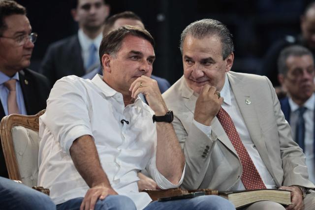 Brazilian senator and Liberal Party (PL) presidential candidate Flavio Bolsonaro (L) and evangelical pastor Silas Malafaia attend the official celebration marking the 100th anniversary of the Assembly of God (Madureira Ministry) at the Maracanazinho Gymnasium in Rio de Janeiro, Brazil, on October 10, 2026. (Photo by Douglas SHINEIDR / AFP)