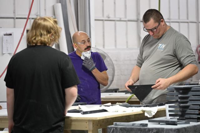 Workers examine a manufactured component at a factory producing kitchen and bathroom products owned by US manufacturer Sam Miller, whose business has been affected by President Donald Trump's tariffs on imported materials, in Warren, Ohio, on September 30, 2026. Since returning to the presidency in January 2025, Trump has wielded executive powers to swiftly slap tariffs on various products and countries. Besides aluminum, his tariffs hit steel and autos too, while US trading partners face country-specific duties. While some American manufacturers have benefited as their foreign competitors encounter higher barriers, others struggle with ballooning costs and persistent uncertainty. (Photo by Chloe FERREUX / AFP)