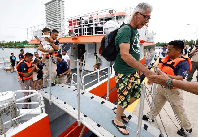 A man disembarks from a ferry carrying 80 people evacuated by Mexican Navy personnel to the facilities of the 12th Naval Zone in Puerto Vallarta, Jalisco state, Mexico, on October 10, 2026, ahead of the potential impact of Hurricane Simon. Hurricane Simon strengthened into a powerful Category 4 storm as it moved toward Mexico's west coast, where it was expected to make landfall late on October 10 or early on October 11. (Photo by ULISES RUIZ / AFP)