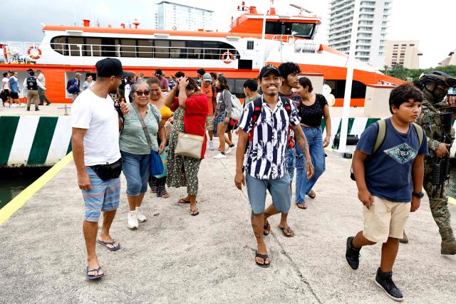 People disembark from a ferry carrying 80 evacuees transported by Mexican Navy personnel to the facilities of the 12th Naval Zone in Puerto Vallarta, Jalisco state, Mexico, on October 10, 2026, ahead of the potential impact of Hurricane Simon. Hurricane Simon strengthened into a powerful Category 4 storm as it moved toward Mexico's west coast, where it was expected to make landfall late on October 10 or early on October 11. (Photo by ULISES RUIZ / AFP)