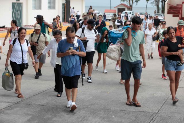 People disembark from a ferry carrying 80 evacuees transported by Mexican Navy personnel to the facilities of the 12th Naval Zone in Puerto Vallarta, Jalisco state, Mexico, on October 10, 2026, ahead of the potential impact of Hurricane Simon. Hurricane Simon strengthened into a powerful Category 4 storm as it moved toward Mexico's west coast, where it was expected to make landfall late on October 10 or early on October 11. (Photo by ULISES RUIZ / AFP)