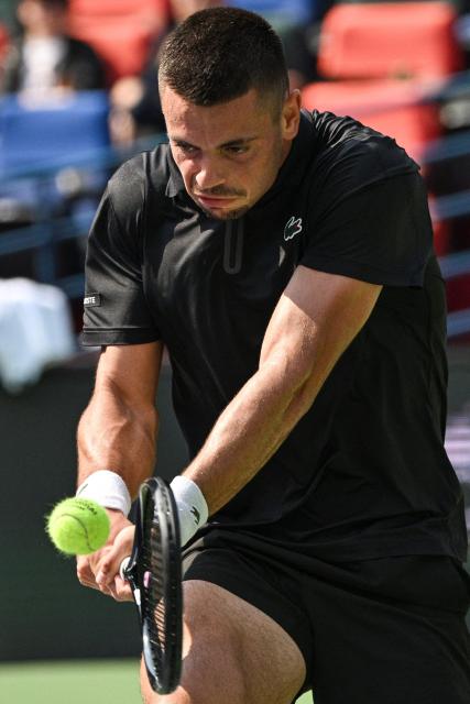 France's Arthur Gea hits a return to USA's Ben Shelton during their men's singles match at the Shanghai Masters tennis tournament in Shanghai on October 11, 2026. (Photo by Hector RETAMAL / AFP)