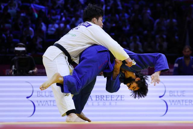 Japan's Goki Tajima (white) competes against Azerbaijan's Zelim Tckaev in the mixed team round of 16 at the World Judo Championships in Baku on October 11, 2026. (Photo by Anne-Christine POUJOULAT / AFP)