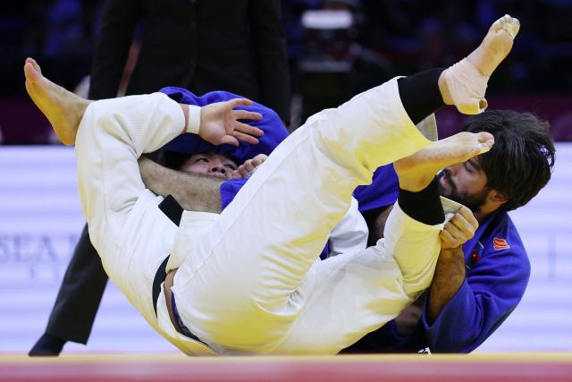 Japan's Goki Tajima (white) competes against Azerbaijan's Zelim Tckaev in the mixed team round of 16 at the World Judo Championships in Baku on October 11, 2026. (Photo by Anne-Christine POUJOULAT / AFP)