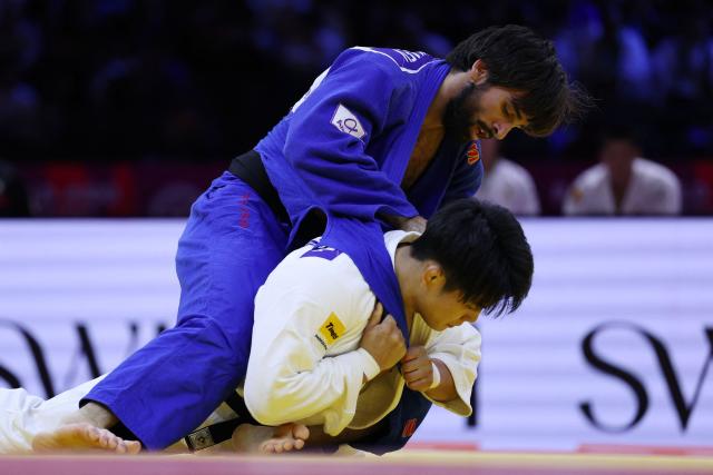 Japan's Goki Tajima (white) competes against Azerbaijan's Zelim Tckaev in the mixed team round of 16 at the World Judo Championships in Baku on October 11, 2026. (Photo by Anne-Christine POUJOULAT / AFP)