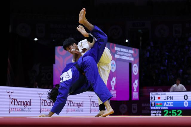 Japan's Goki Tajima (white) competes against Azerbaijan's Zelim Tckaev in the mixed team round of 16 at the World Judo Championships in Baku on October 11, 2026. (Photo by Anne-Christine POUJOULAT / AFP)