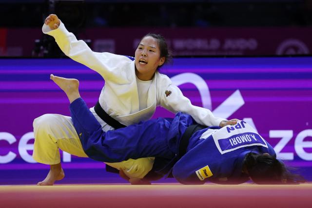 Mongolia's Ariunzaya Terbish (white) competes against Japan's Akari Omori in the mixed team quarter-final at the World Judo Championships in Baku on October 11, 2026. (Photo by Anne-Christine POUJOULAT / AFP)
