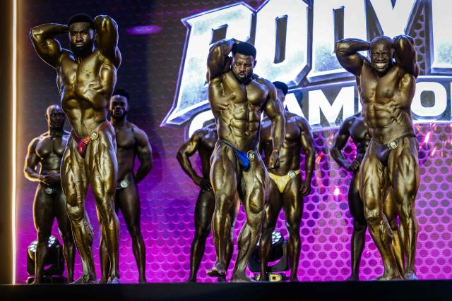 Competitor in the Men's Open Bodybuilding category strike poses on stage during the 2026 Body Fuel International Fitness Championship in Nairobi on October 10, 2026. The 2026 Body Fuel Fitness Championship brought together athletes from across Africa and beyond, highlighting the growing popularity of bodybuilding and competitive fitness on the continent. (Photo by Luis TATO / AFP)
