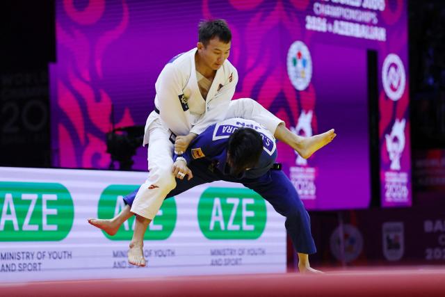 Mongolia's Uranbayar Odgerel (white) competes against Japan's Shusuke Uchimura in the mixed team quarter-final at the World Judo Championships in Baku on October 11, 2026. (Photo by Anne-Christine POUJOULAT / AFP)