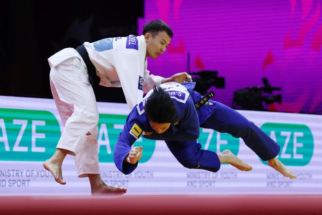 Mongolia's Uranbayar Odgerel (white) competes against Japan's Shusuke Uchimura in the mixed team quarter-final at the World Judo Championships in Baku on October 11, 2026. (Photo by Anne-Christine POUJOULAT / AFP)