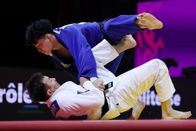 Mongolia's Uranbayar Odgerel (white) competes against Japan's Shusuke Uchimura in the mixed team quarter-final at the World Judo Championships in Baku on October 11, 2026. (Photo by Anne-Christine POUJOULAT / AFP)