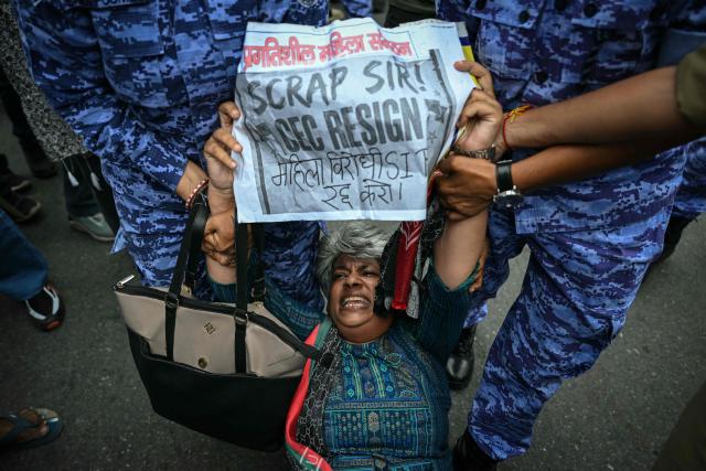 Security personnel detain an activist during a protest demanding the resignation of India’s Chief Election Commissioner Gyanesh Kumar over alleged voter roll irregularities linked to the "special intensive revision" (SIR), near Jantar Mantar in New Delhi on October 11, 2026. (Photo by Sajjad HUSSAIN / AFP)
