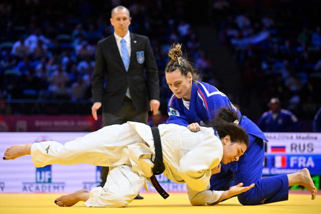 Russia's Madina Taimazova (white) competes against France's Clemence Eme in the mixed team quarter-final at the World Judo Championships in Baku on October 11, 2026. (Photo by Alexander NEMENOV / AFP)
