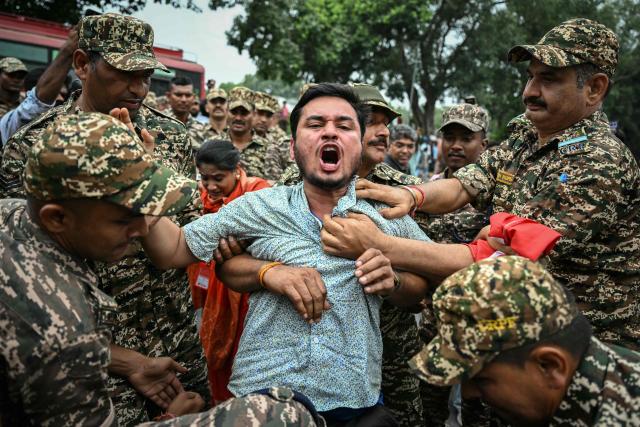 Security personnel detain a member of All India Youth Federation (AIYF) during a protest demanding the resignation of India's Chief Election Commissioner Gyanesh Kumar over alleged voter roll irregularities linked to the "special intensive revision" (SIR), near Jantar Mantar in New Delhi on October 11, 2026. (Photo by Sajjad HUSSAIN / AFP)