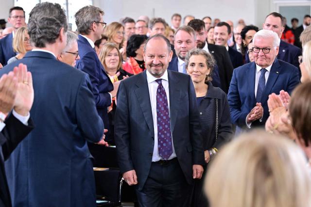 Laureate British-French lawyer and writer Philippe Sands (C) reacts next to his wife Natalia Schiffrin (C-R) as German President Frank-Walter Steinmeier (R) and other guests applaud during the awarding ceremony for the 2026 Peace Prize of the German Book Trade at the St Paul's Church in Frankfurt am Main, western Germany on October 11, 2026. In its statement, the jury wrote: 'As one of the most important intellectual voices of our time, the French-British lawyer and writer advocates for justice, peace, and the steadfast defense of international law. A descendant of Holocaust survivors, he uses his own family history to show how this body of law came into being and what experiences lie behind the legal concepts of 'genocide' and 'crimes against humanity'.' (Photo by Thomas Lohnes / POOL / AFP)