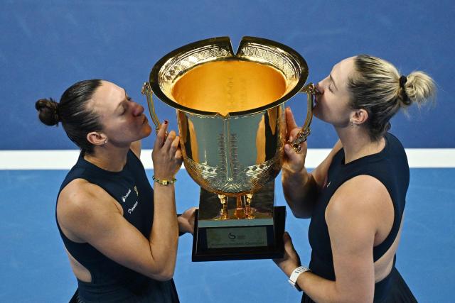 Brazil’s Luisa Stefani (L) and Canada’s Gabriela Dabrowski kiss the trophy after beating Czech Republic’s Katerina Siniakova and China’s Zhang Shuai in the women’s doubles final at the China Open tennis tournament in Beijing on October 11, 2026. (Photo by PEDRO PARDO / AFP)