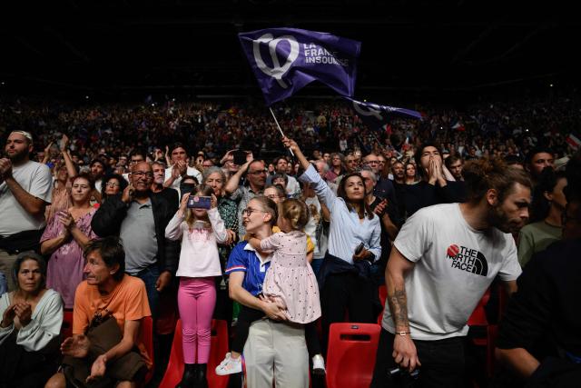 Supporters wave party flags as they attend the Leftist party La France Insoumise (LFI) candidate in France's 2027 presidential election Jean-Luc Melenchon's campaign rally for the 2027 presidential election at the Zenith concert hall in Cournon-d’Auvergne on October 11, 2026. (Photo by JEFF PACHOUD / AFP)