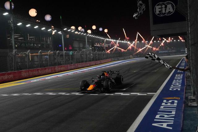 Red Bull Racing's Dutch driver Max Verstappen crosses the chequered flag at the finish line to win the Formula One Singapore Grand Prix at the Marina Bay Street Circuit in Singapore on October 11, 2026. (Photo by Ng Han Guan / POOL / AFP)
