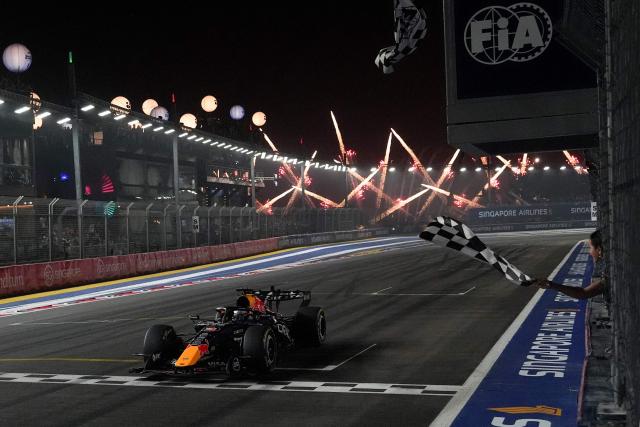 Red Bull Racing's Dutch driver Max Verstappen crosses the chequered flag at the finish line to win the Formula One Singapore Grand Prix at the Marina Bay Street Circuit in Singapore on October 11, 2026. (Photo by Ng Han Guan / POOL / AFP)
