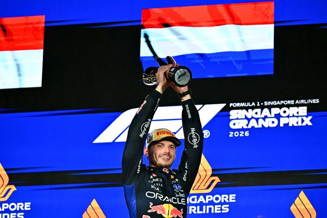 Winner Red Bull Racing's Dutch driver Max Verstappen lifts his trophy as he celebrates on the podium after the Formula One Singapore Grand Prix at the Marina Bay Street Circuit in Singapore on October 11, 2026. (Photo by Lillian SUWANRUMPHA / AFP)