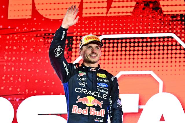 Winner Red Bull Racing's Dutch driver Max Verstappen waves to supporters as he celebrates on the podium after the Formula One Singapore Grand Prix at the Marina Bay Street Circuit in Singapore on October 11, 2026. (Photo by Lillian SUWANRUMPHA / AFP)