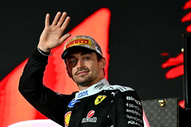 Second-placed Ferrari's Monegasque driver Charles Leclerc waves to supporters as he celebrates on the podium after the Formula One Singapore Grand Prix at the Marina Bay Street Circuit in Singapore on October 11, 2026. (Photo by Lillian SUWANRUMPHA / AFP)