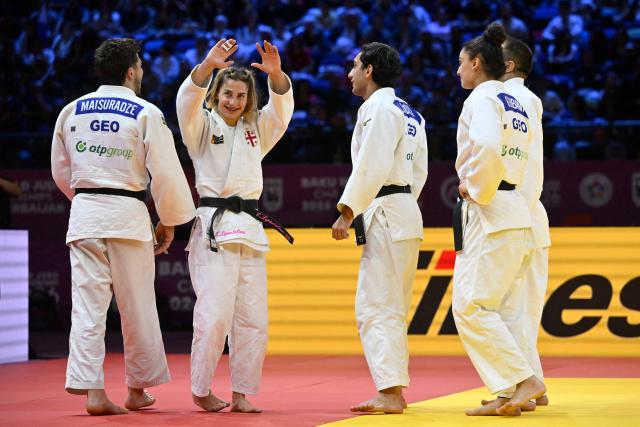 Georgia's Eteri Liparteliani (2nd L) and her teammates celebrate winning the mixed team bronze medal bout at the World Judo Championships in Baku on October 11, 2026. (Photo by Alexander NEMENOV / AFP)