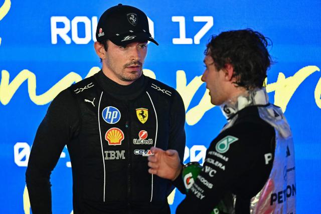 Second-placed Ferrari's Monegasque driver Charles Leclerc (L) speaks with third-placed Mercedes' Italian driver Kimi Antonelli on the podium after the Formula One Singapore Grand Prix at the Marina Bay Street Circuit in Singapore on October 11, 2026. (Photo by Lillian SUWANRUMPHA / AFP)