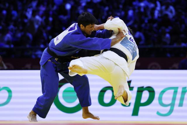 Mongolia's Uranbayar Odgerel (white) competes against Uzbekistan's Shakhram Ahadov in the mixed team bronze medal bout at the World Judo Championships in Baku on October 11, 2026. (Photo by Anne-Christine POUJOULAT / AFP)