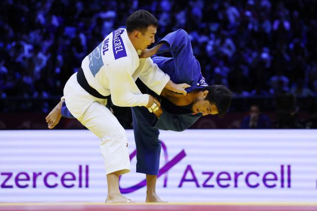 Mongolia's Uranbayar Odgerel (white) competes against Uzbekistan's Shakhram Ahadov in the mixed team bronze medal bout at the World Judo Championships in Baku on October 11, 2026. (Photo by Anne-Christine POUJOULAT / AFP)